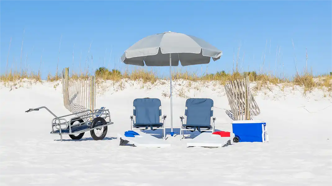 rented beach chairs, umbrella, corn hole and cooler on the beach